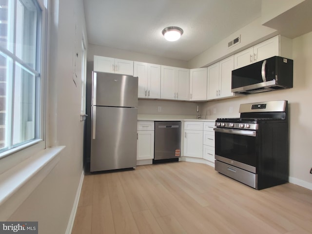 100 Park Blvd Unit 14A, Cherry Hill, NJ 08034 - kitchen with appliances with stainless steel finishes, baseboards, white cabinetry, and plenty of natural light