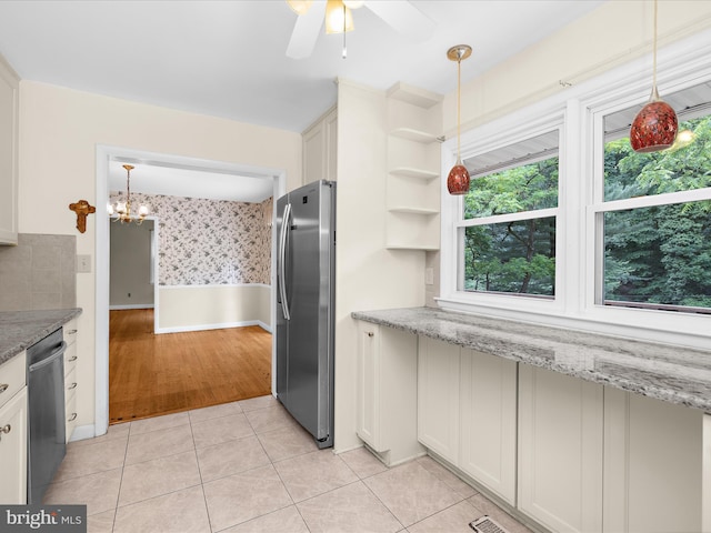 6748 Glenkirk Rd, Baltimore, MD 21239 - kitchen with stainless steel appliances, light tile patterned floors, a ceiling fan, a chandelier, and light stone countertops