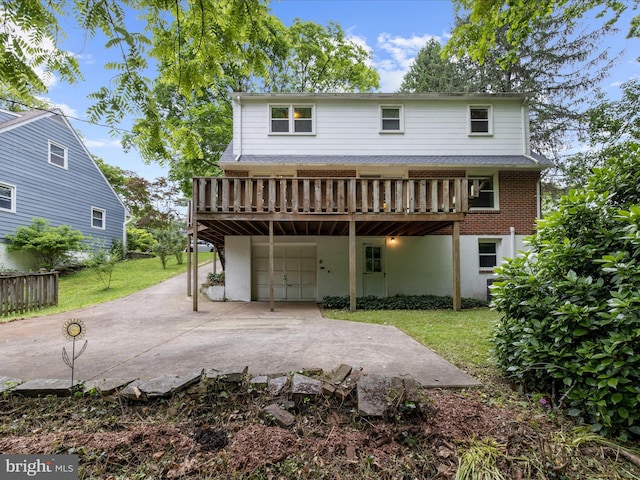 6748 Glenkirk Rd, Baltimore, MD 21239 - rear view of house featuring an attached garage, concrete driveway, a yard, a wooden deck, and a patio area