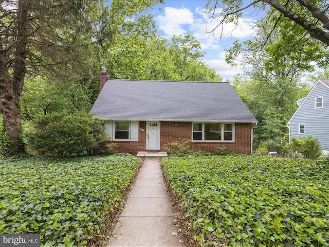 6748 Glenkirk Rd, Baltimore, MD 21239 - view of front facade with a chimney, brick siding, and a shingled roof
