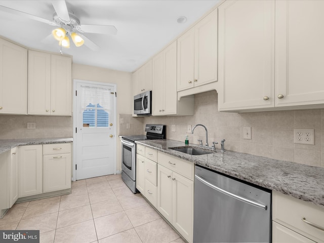 6748 Glenkirk Rd, Baltimore, MD 21239 - kitchen featuring stainless steel appliances, a sink, decorative backsplash, and light tile patterned flooring