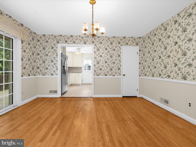 6748 Glenkirk Rd, Baltimore, MD 21239 - unfurnished dining area with wallpapered walls, light wood finished floors, a chandelier, baseboards, and a ceiling fan