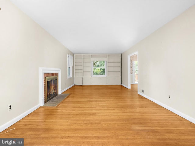 6748 Glenkirk Rd, Baltimore, MD 21239 - unfurnished living room featuring a fireplace, built in shelves, baseboards, and light wood-type flooring