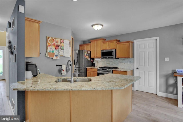 7 Kantner Ln N, Reading, PA 19607 - kitchen featuring stainless steel appliances, a sink, a peninsula, light stone countertops, and light wood-style floors