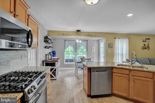 7 Kantner Ln N, Reading, PA 19607 - kitchen with appliances with stainless steel finishes, a sink, light wood finished floors, light stone countertops, and backsplash
