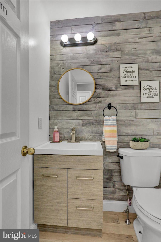 7 Kantner Ln N, Reading, PA 19607 - bathroom with toilet, vanity, baseboards, wood finished floors, and wooden walls