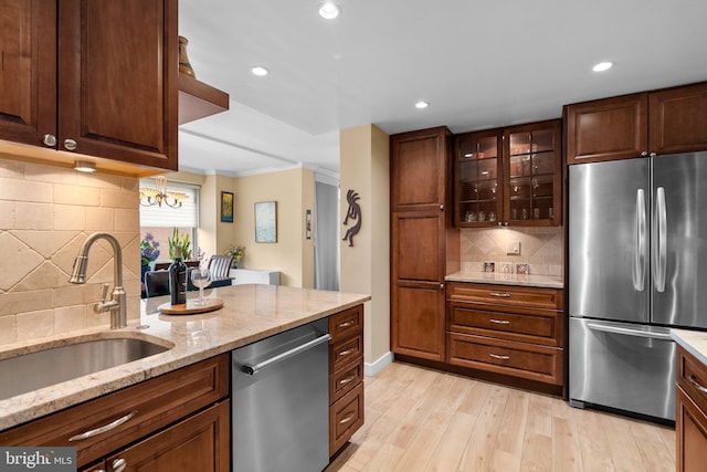 4515 Willard Ave Unit 610S, Chevy Chase, MD 20815 - kitchen featuring stainless steel appliances, a sink, backsplash, light wood finished floors, and light stone counters