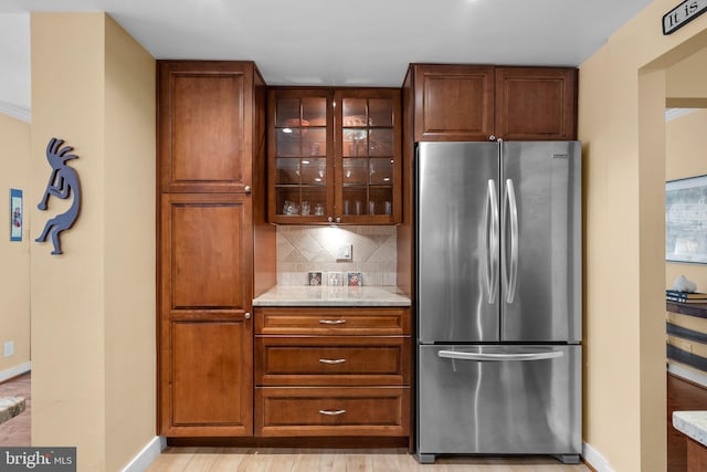 4515 Willard Ave Unit 610S, Chevy Chase, MD 20815 - kitchen with freestanding refrigerator, baseboards, backsplash, glass insert cabinets, and light stone countertops