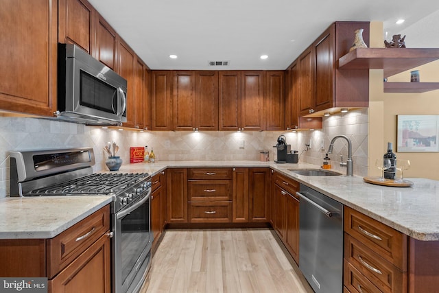4515 Willard Ave Unit 610S, Chevy Chase, MD 20815 - kitchen featuring stainless steel appliances, a sink, light stone counters, light wood finished floors, and tasteful backsplash