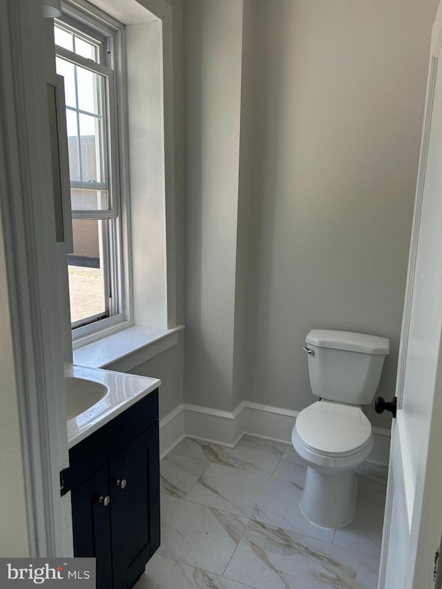 825 Jersey Ave, Gloucester City, NJ 08030 - half bathroom featuring marble look tile flooring, vanity, toilet, and plenty of natural light