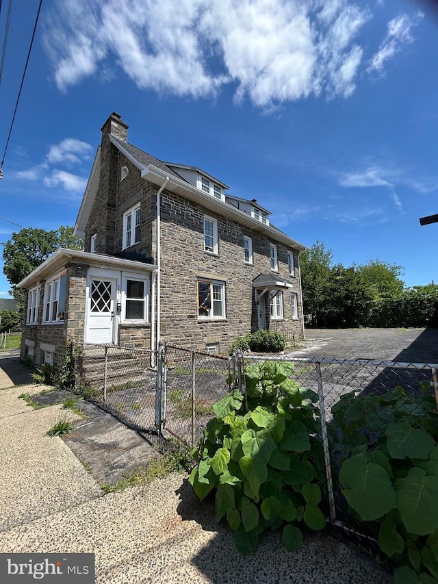 825 Jersey Ave, Gloucester City, NJ 08030 - view of home's exterior featuring a chimney and stone siding