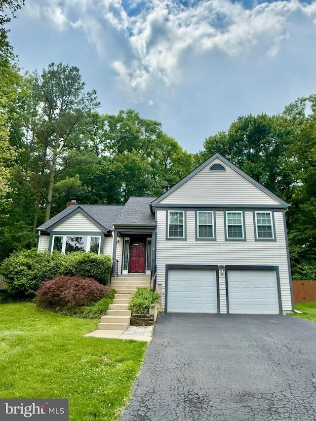 9003 Triple Ridge Rd, Fairfax Station, VA 22039 - split level home featuring an attached garage, driveway, and view of wooded area