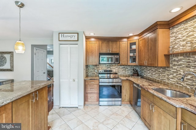 2 E Park Rd, Newtown, PA 18940 - kitchen with appliances with stainless steel finishes, a sink, brown cabinets, and decorative backsplash