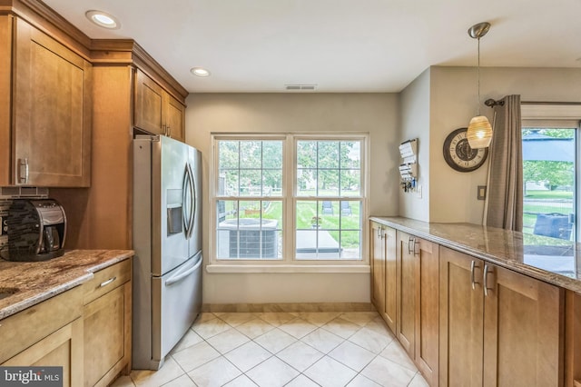 2 E Park Rd, Newtown, PA 18940 - kitchen with stainless steel fridge with ice dispenser, brown cabinets, baseboards, light stone counters, and decorative light fixtures