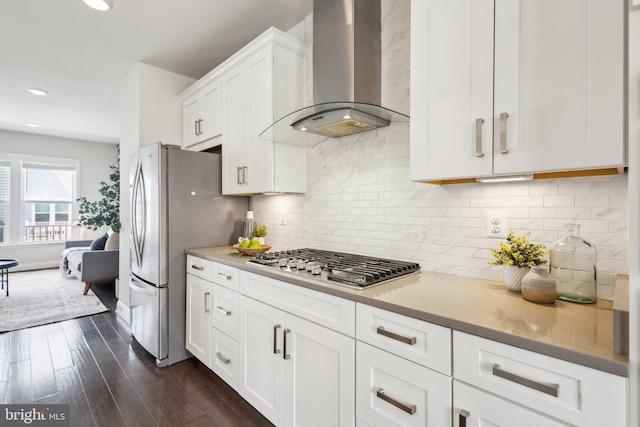 1909 Greenbriar Hall Rd, Dumfries, VA 22026 - kitchen featuring wall chimney exhaust hood, appliances with stainless steel finishes, white cabinets, dark wood finished floors, and tasteful backsplash
