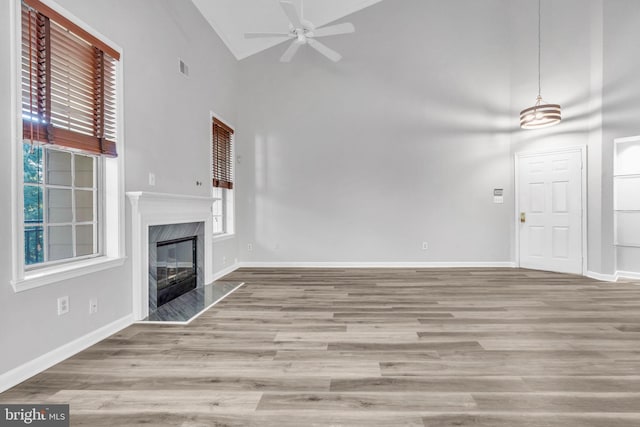 1334 Garden Wall Cir Unit 407, Reston, VA 20194 - unfurnished living room with a ceiling fan, high vaulted ceiling, wood finished floors, baseboards, and a high end fireplace