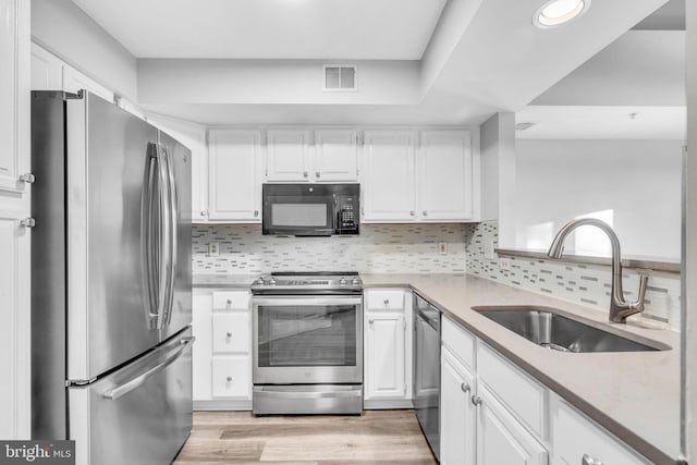 1334 Garden Wall Cir Unit 407, Reston, VA 20194 - kitchen with stainless steel appliances, a sink, white cabinetry, backsplash, and recessed lighting