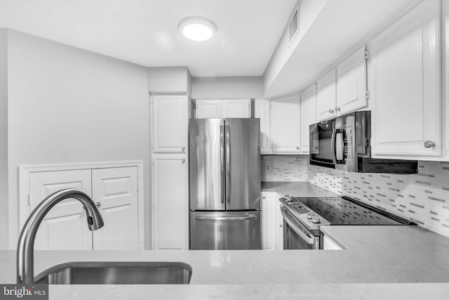 1334 Garden Wall Cir Unit 407, Reston, VA 20194 - kitchen with stainless steel appliances, a sink, backsplash, white cabinetry, and light countertops