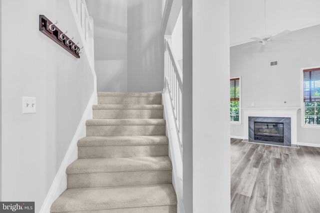 1334 Garden Wall Cir Unit 407, Reston, VA 20194 - stairway featuring a high ceiling, wood finished floors, ceiling fan, baseboards, and a high end fireplace