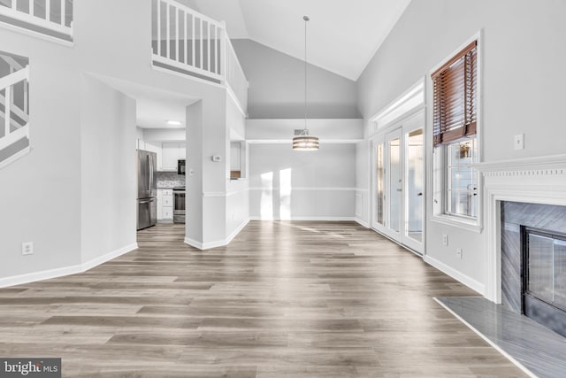 1334 Garden Wall Cir Unit 407, Reston, VA 20194 - unfurnished living room with a fireplace, wood finished floors, baseboards, and high vaulted ceiling