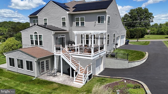 7425 Signal Hill Rd, Manassas, VA 20111 - back of property featuring solar panels, asphalt driveway, a wooden deck, french doors, and a lawn