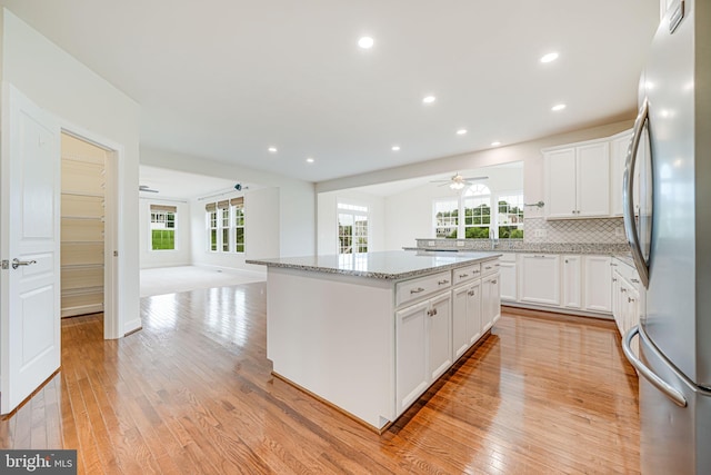 7425 Signal Hill Rd, Manassas, VA 20111 - kitchen featuring freestanding refrigerator, a ceiling fan, open floor plan, a kitchen island, and light stone countertops