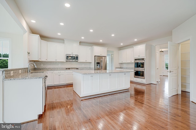 7425 Signal Hill Rd, Manassas, VA 20111 - kitchen with stainless steel appliances, backsplash, a center island, white cabinetry, and recessed lighting