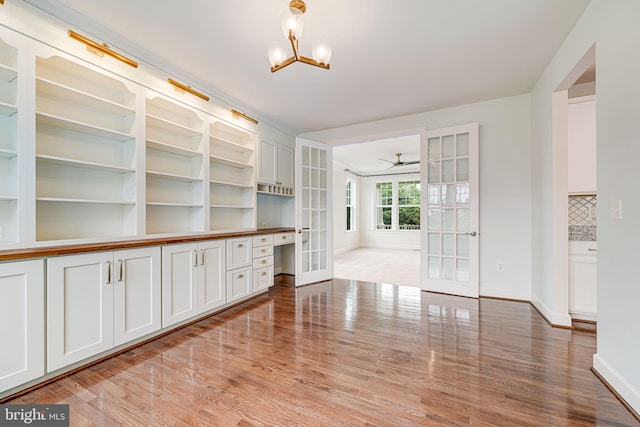 7425 Signal Hill Rd, Manassas, VA 20111 - unfurnished living room featuring french doors, wood finished floors, a chandelier, and ceiling fan