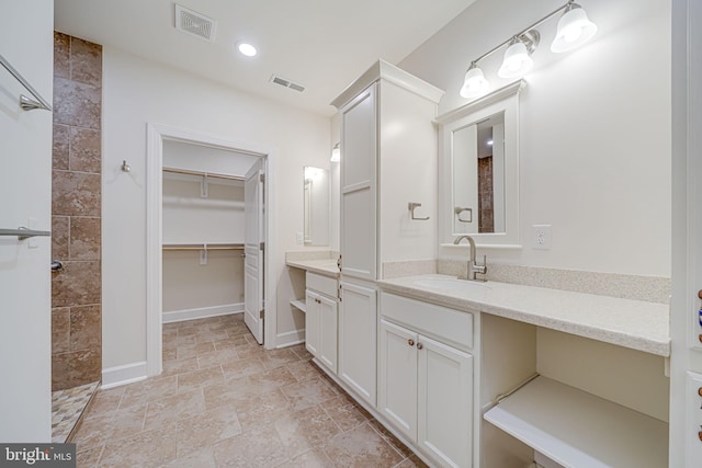 7425 Signal Hill Rd, Manassas, VA 20111 - bathroom featuring vanity, tiled shower, stone finish flooring, and recessed lighting