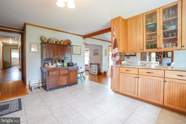 5509 Waterview Dr, Cambridge, MD 21613 - kitchen with ornamental molding, plenty of natural light, light tile patterned floors, and glass insert cabinets