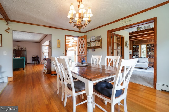 5509 Waterview Dr, Cambridge, MD 21613 - dining area featuring a textured ceiling, a chandelier, light wood finished floors, ornamental molding, and a baseboard radiator