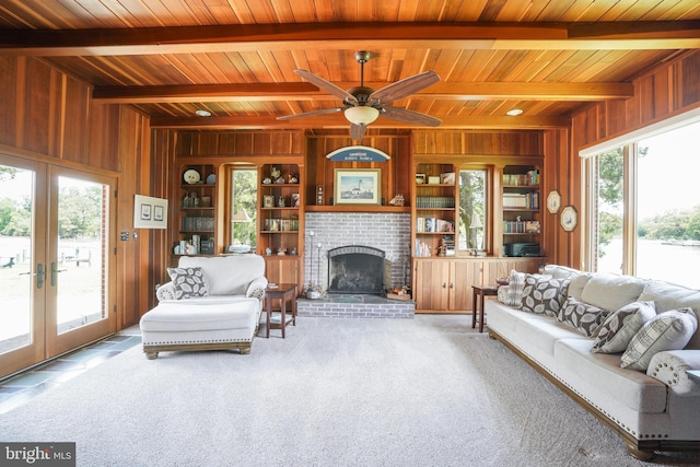 5509 Waterview Dr, Cambridge, MD 21613 - living area featuring wood walls, wood ceiling with exposed beams, french doors, carpet floors, and a brick fireplace