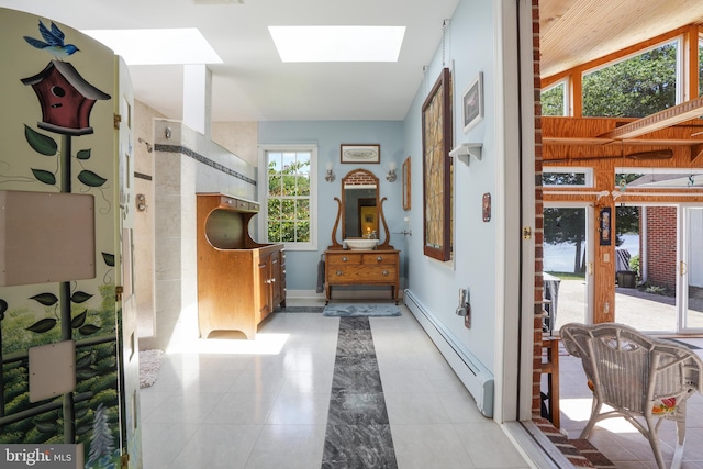 5509 Waterview Dr, Cambridge, MD 21613 - hallway with baseboard heating, a skylight, baseboards, and light tile patterned floors