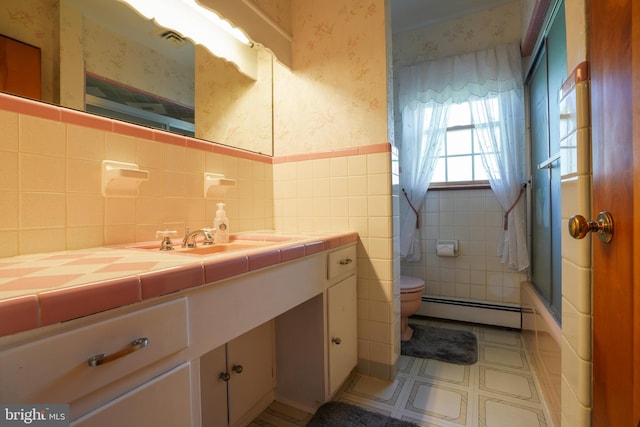 5509 Waterview Dr, Cambridge, MD 21613 - bathroom featuring wallpapered walls, baseboard heating, toilet, vanity, and a wainscoted wall