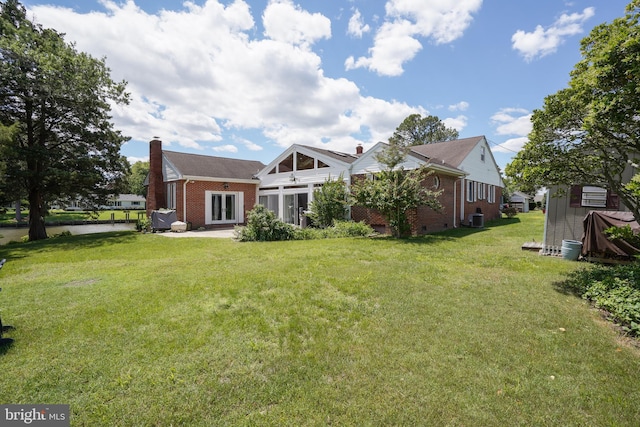 5509 Waterview Dr, Cambridge, MD 21613 - rear view of property featuring brick siding, a chimney, cooling unit, and a yard