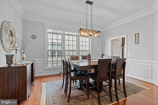 42735 Macauley Pl, Ashburn, VA 20148 - dining room featuring ornamental molding, a chandelier, wainscoting, and wood finished floors