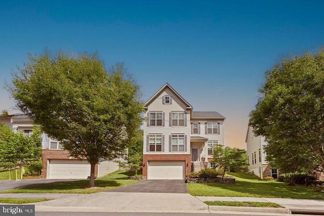 42735 Macauley Pl, Ashburn, VA 20148 - view of front of property featuring an attached garage, asphalt driveway, a front lawn, board and batten siding, and brick siding