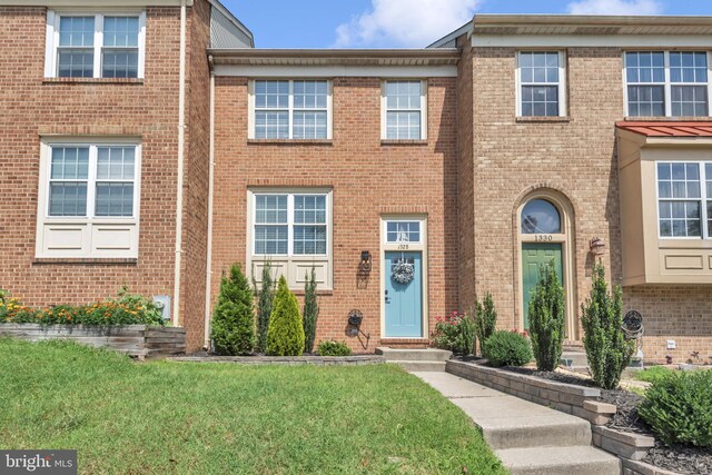 1328 Cox Cv, Stoney Beach, MD 21226 - townhome / multi-family property with brick siding and a front lawn