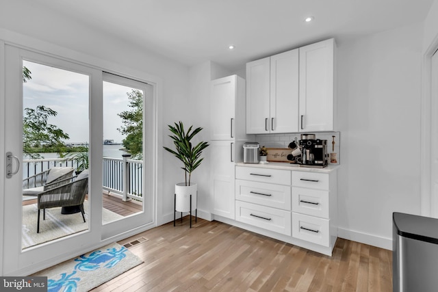 1328 Cox Cv, Stoney Beach, MD 21226 - kitchen with decorative backsplash, white cabinets, recessed lighting, light wood-type flooring, and baseboards