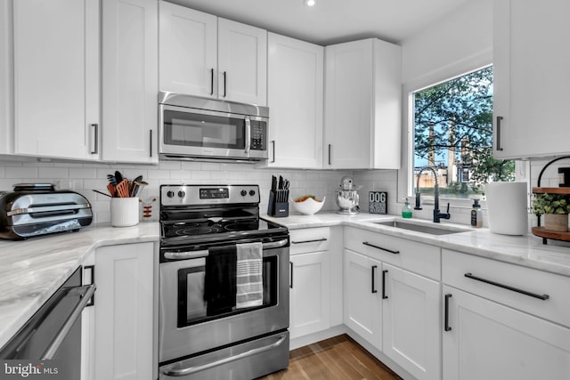 1328 Cox Cv, Stoney Beach, MD 21226 - kitchen with stainless steel appliances, a sink, white cabinets, backsplash, and light stone countertops