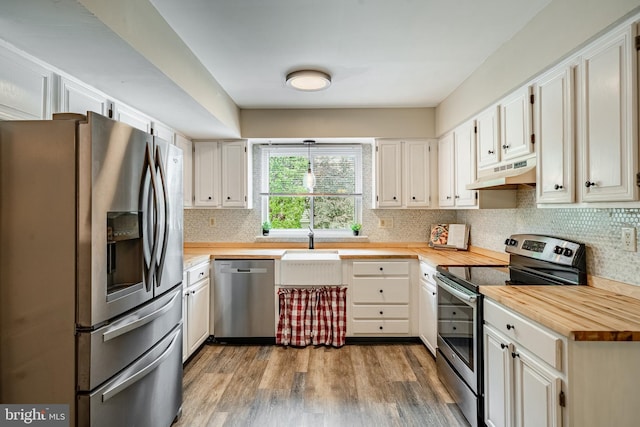 2806 Eagle Rd Unit 2806, West Chester, PA 19382 - kitchen featuring stainless steel appliances, wood counters, under cabinet range hood, and tasteful backsplash