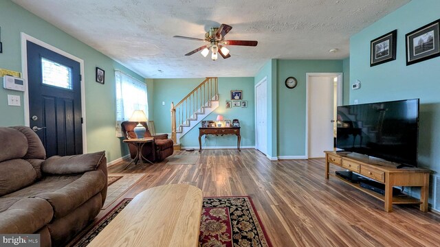 12 Rogers Cir, Newark, DE 19702 - living room with wood finished floors, stairs, a ceiling fan, a textured ceiling, and baseboards