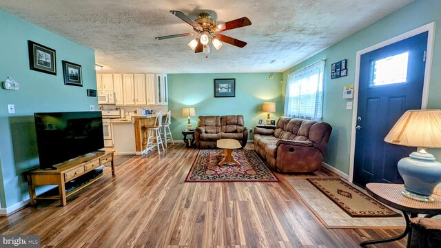12 Rogers Cir, Newark, DE 19702 - living room featuring a ceiling fan, wood finished floors, baseboards, and a textured ceiling