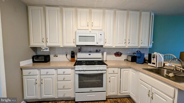 12 Rogers Cir, Newark, DE 19702 - kitchen featuring white appliances, a sink, decorative backsplash, and white cabinetry