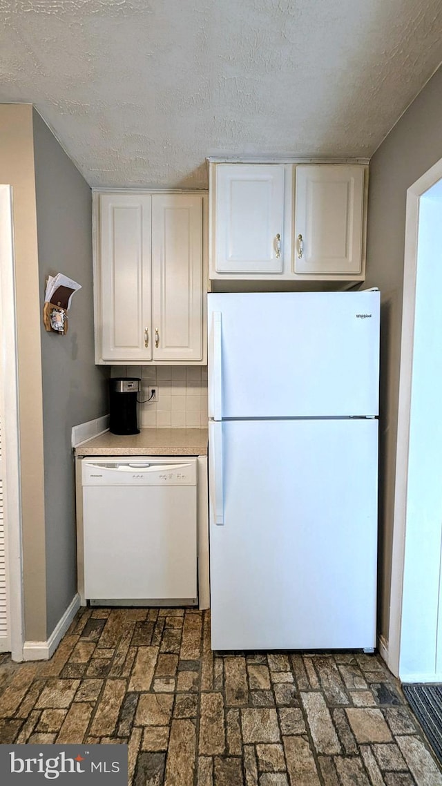12 Rogers Cir, Newark, DE 19702 - kitchen with white appliances, white cabinets, baseboards, a textured ceiling, and brick patterned flooring
