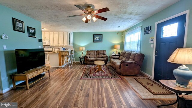 12 Rogers Cir, Newark, DE 19702 - living area featuring a ceiling fan, wood finished floors, baseboards, and a textured ceiling