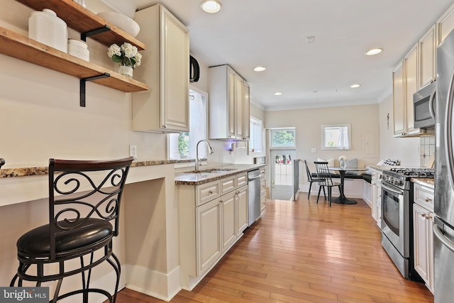 1201 Cooksie St, Baltimore, MD 21230 - kitchen with appliances with stainless steel finishes, light stone counters, light wood-type flooring, crown molding, and open shelves