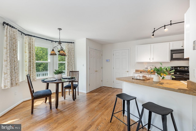 11 Basalt Dr, Fredericksburg, VA 22406 - kitchen featuring black appliances, a kitchen bar, white cabinetry, light wood-style flooring, and butcher block countertops