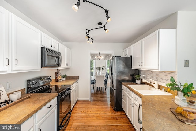 11 Basalt Dr, Fredericksburg, VA 22406 - kitchen featuring black appliances, white cabinetry, light wood-style flooring, decorative backsplash, and a chandelier