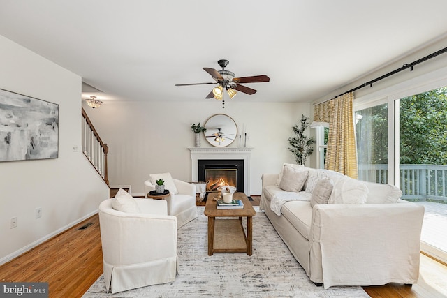 11 Basalt Dr, Fredericksburg, VA 22406 - living room with light wood-style flooring, a glass covered fireplace, ceiling fan, and stairs